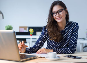 Portrait of beautiful young woman working with laptop in her office.